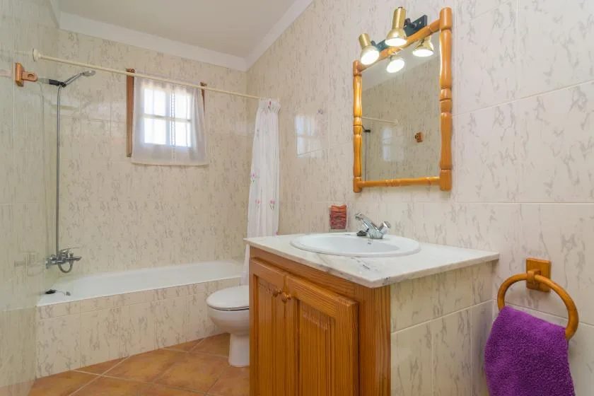 Un baño con bañera, lavabo con mueble y espejo.