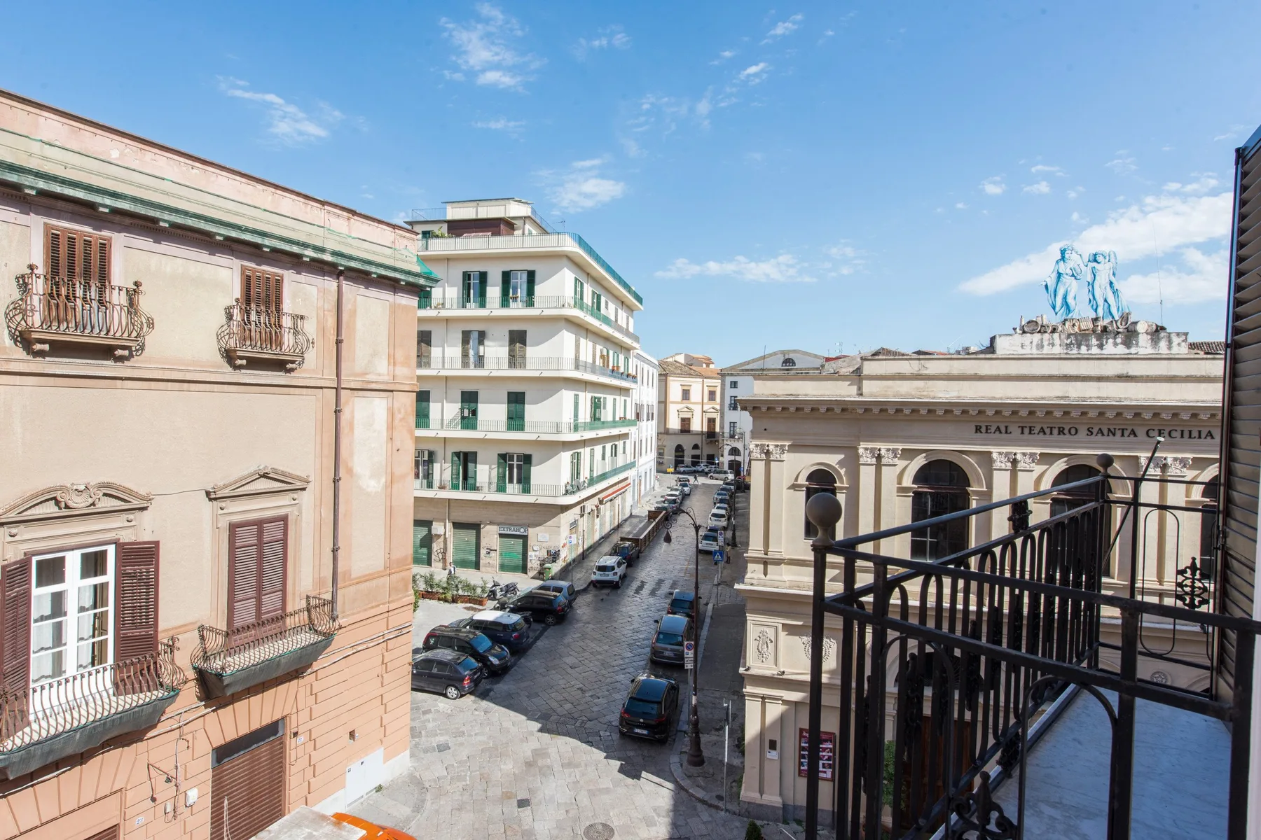 Una calle de la ciudad vista desde arriba, con edificios históricos y autos estacionados.