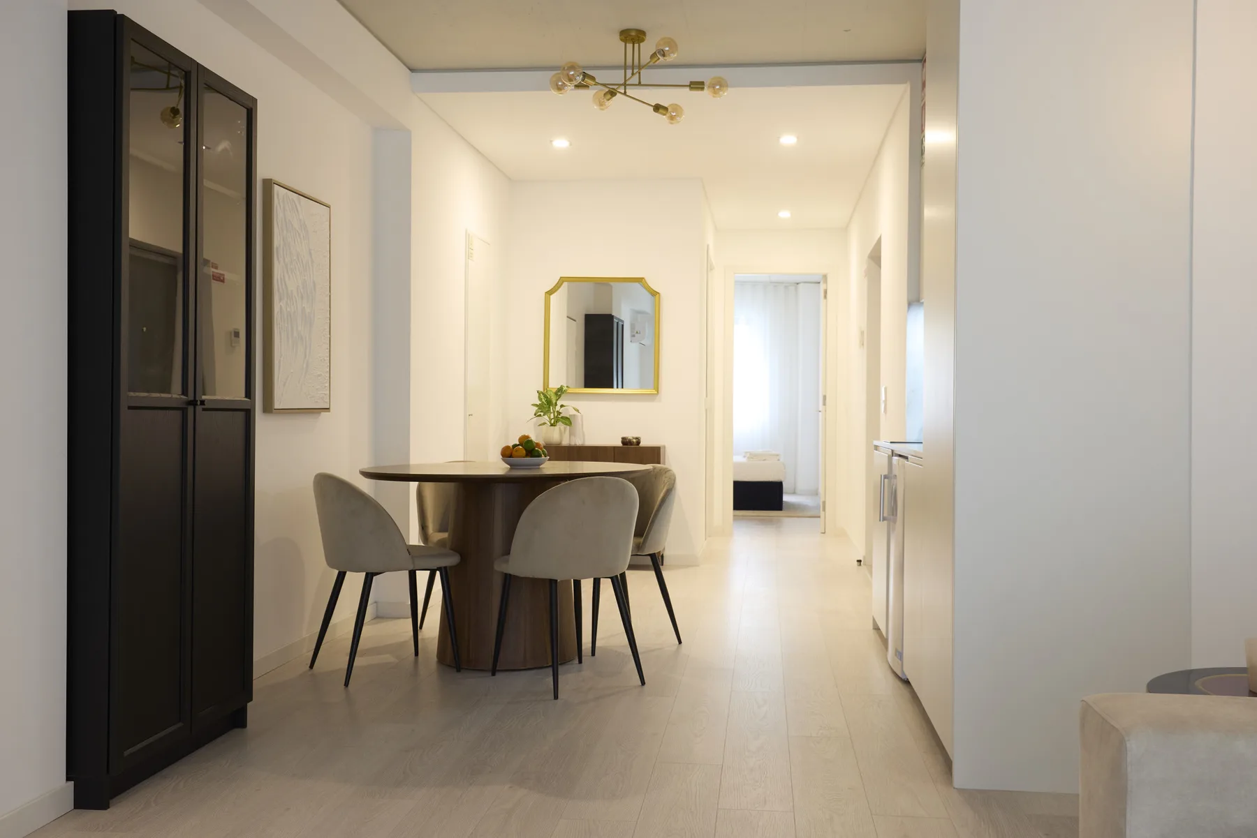 A dining area with a table and seating beside a hallway.