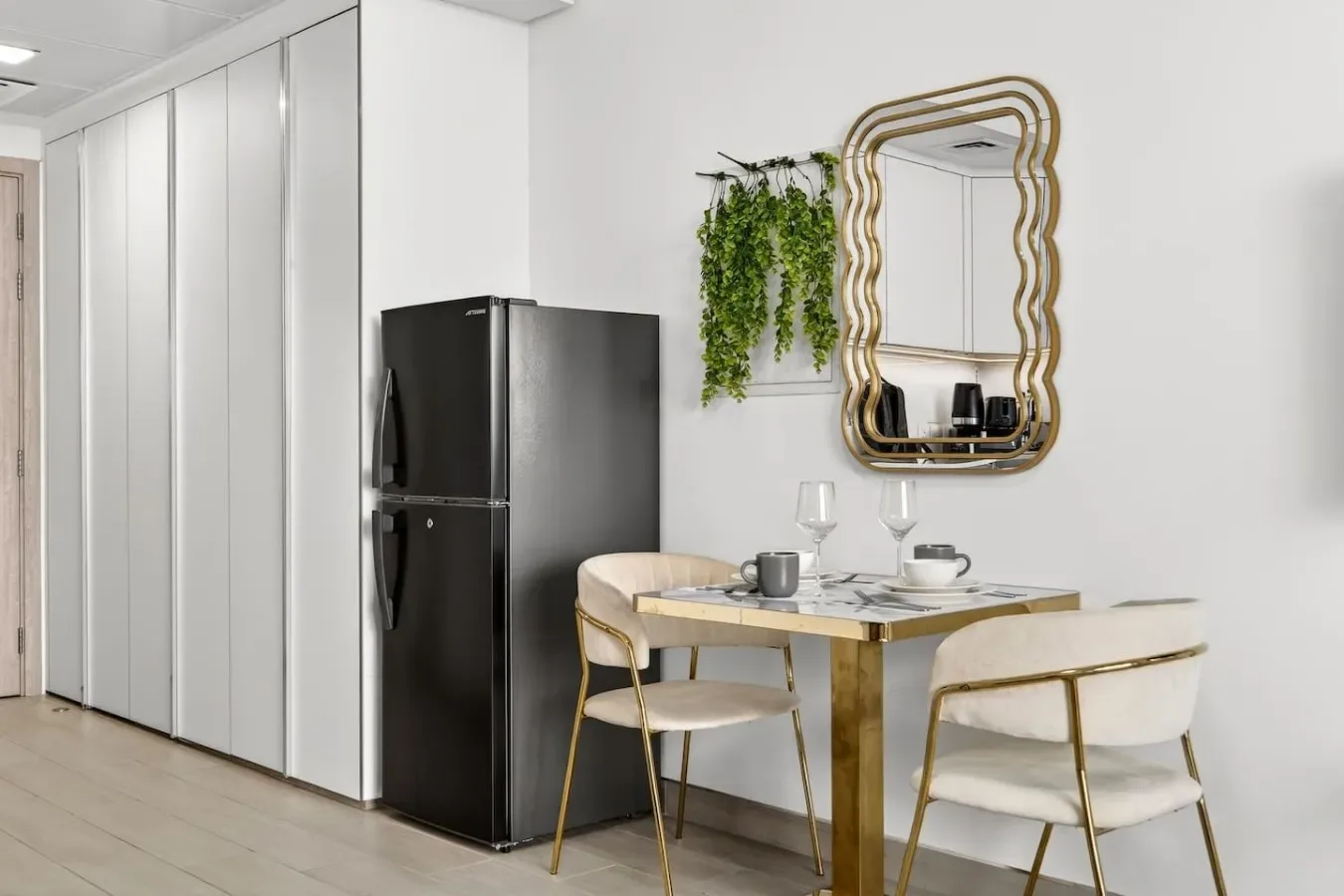 A dining area with a table, chairs, and a black refrigerator.