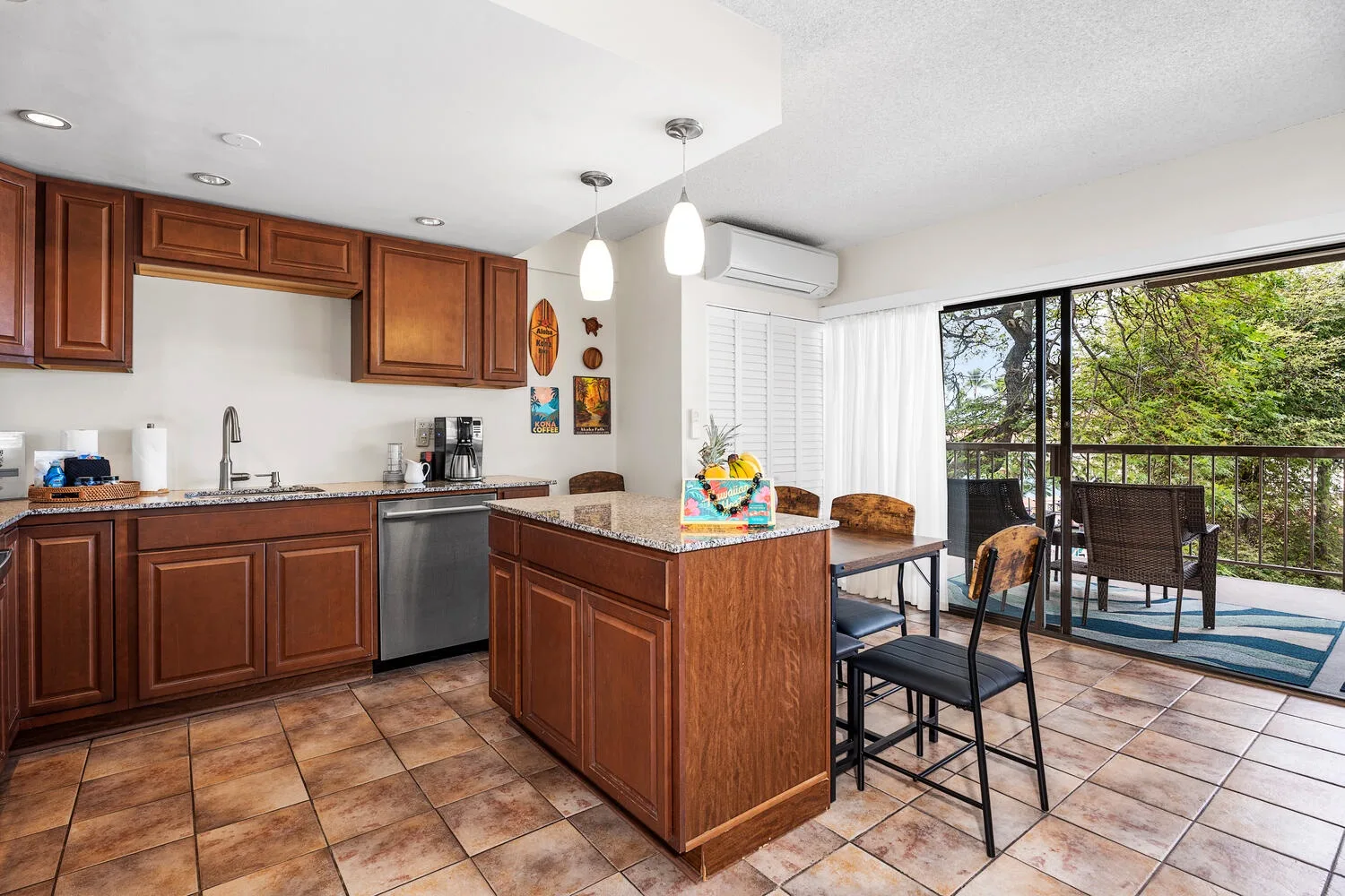 Una cocina se abre a un comedor junto a puertas de vidrio que dan a un balcón.