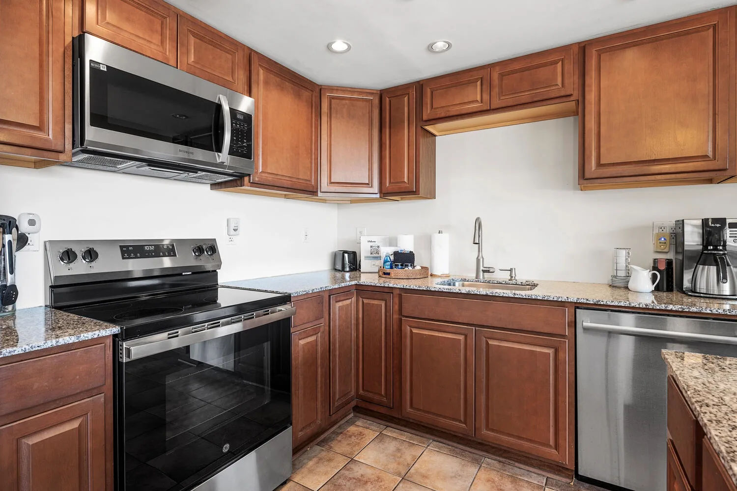 Una cocina con gabinetes de madera, una estufa y un fregadero.