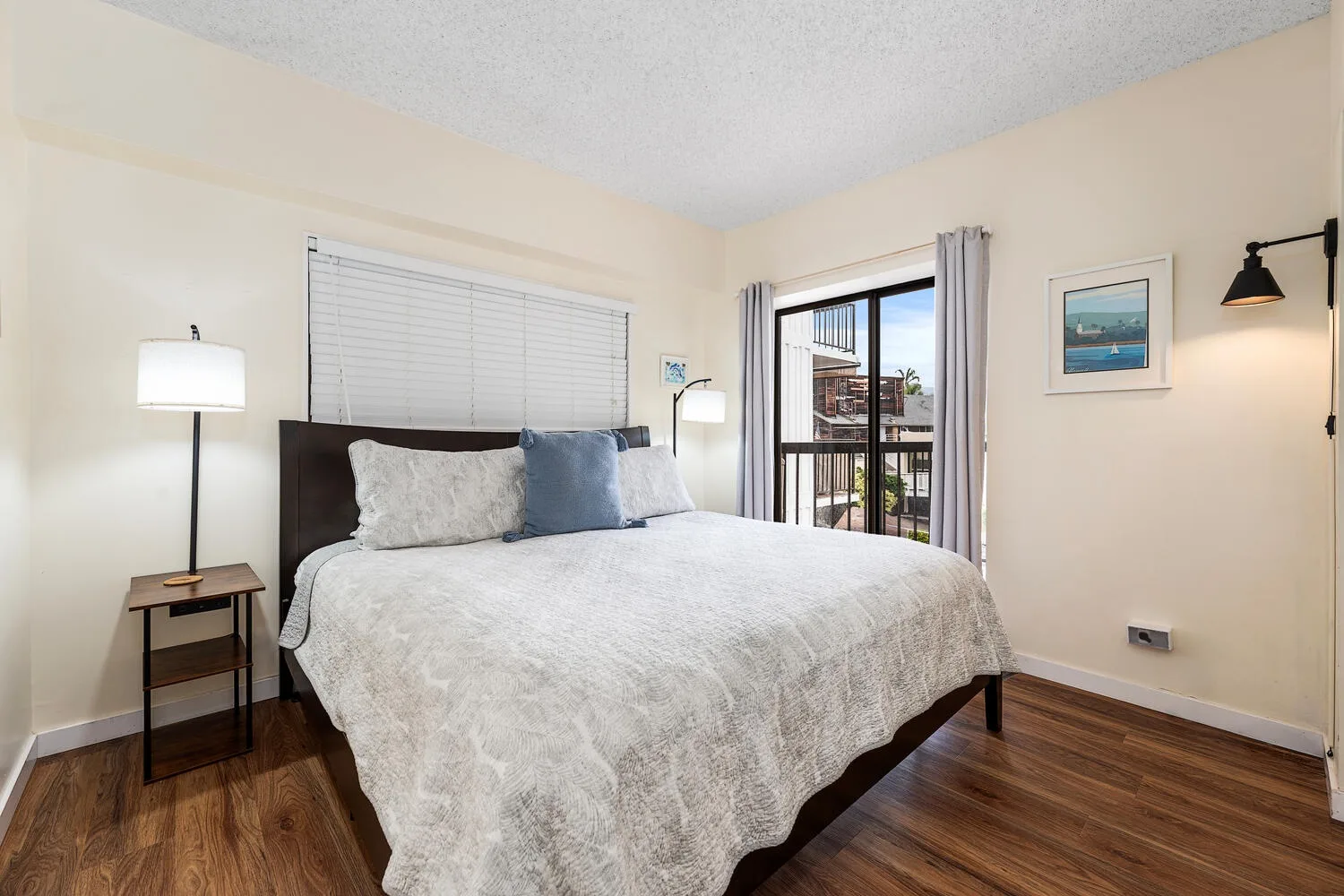 Un dormitorio con una cama grande, una ventana y suelo de madera.