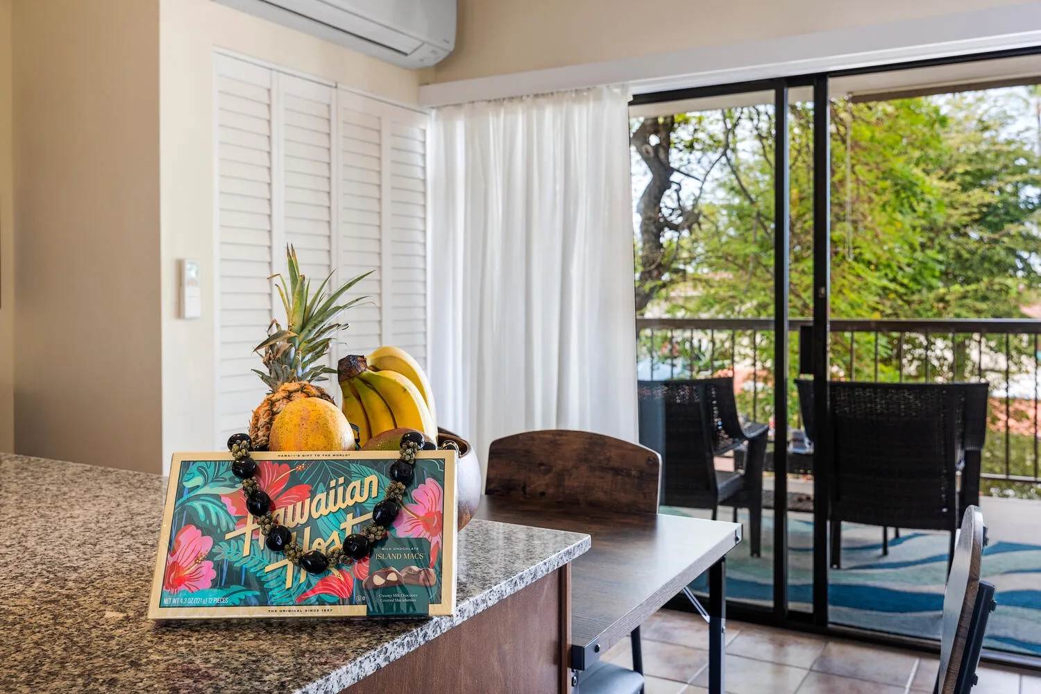 Comedor junto a puertas corredizas de vidrio, con frutas sobre la encimera.