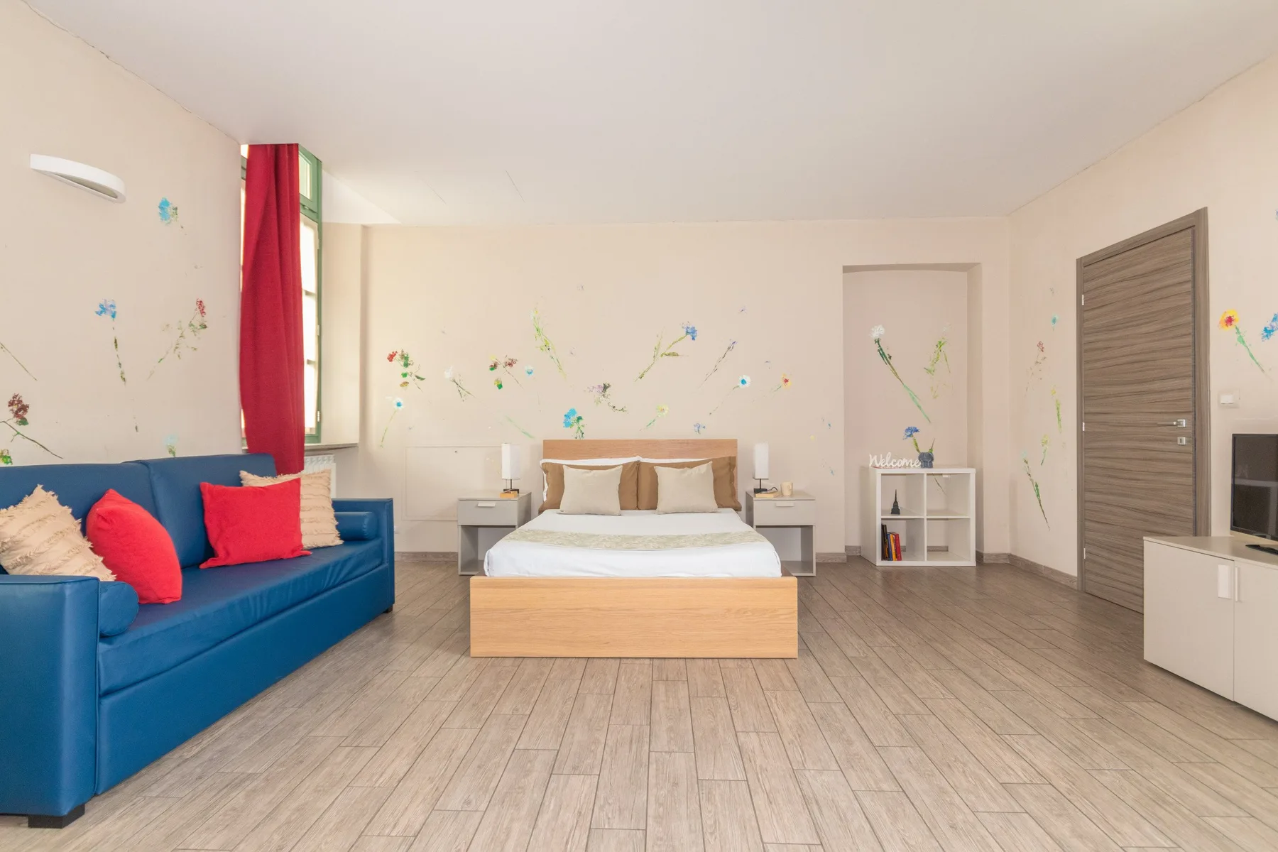Un dormitorio con una cama y asientos azules, decorado con pequeños adhesivos en la pared.