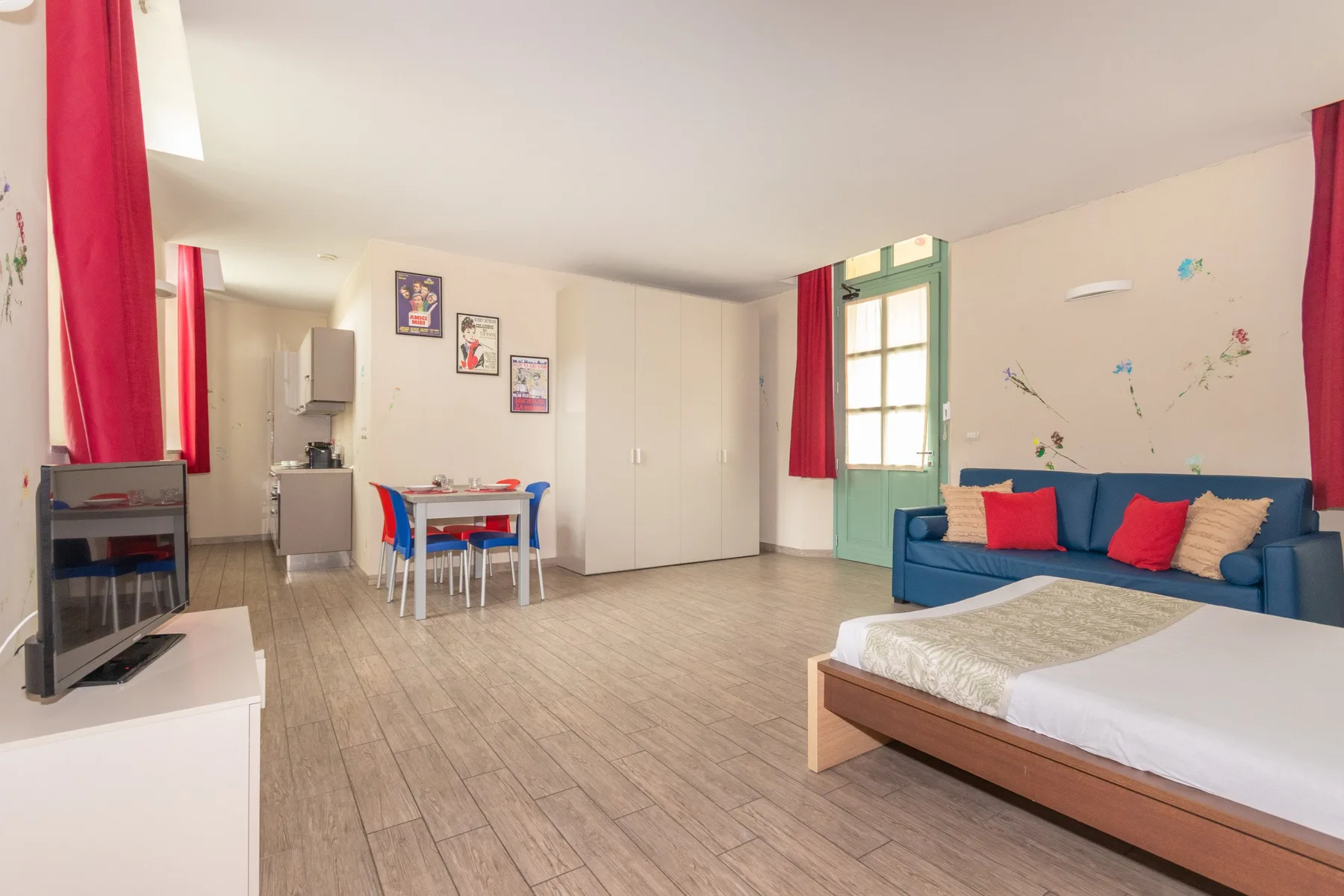 Una sala de estar y comedor luminosa, con una zona de asientos azul y una mesa pequeña.