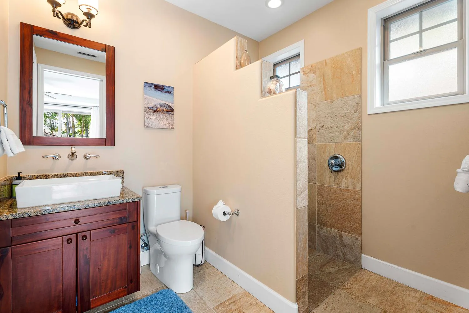 A bathroom with a vanity, toilet, and tiled shower.