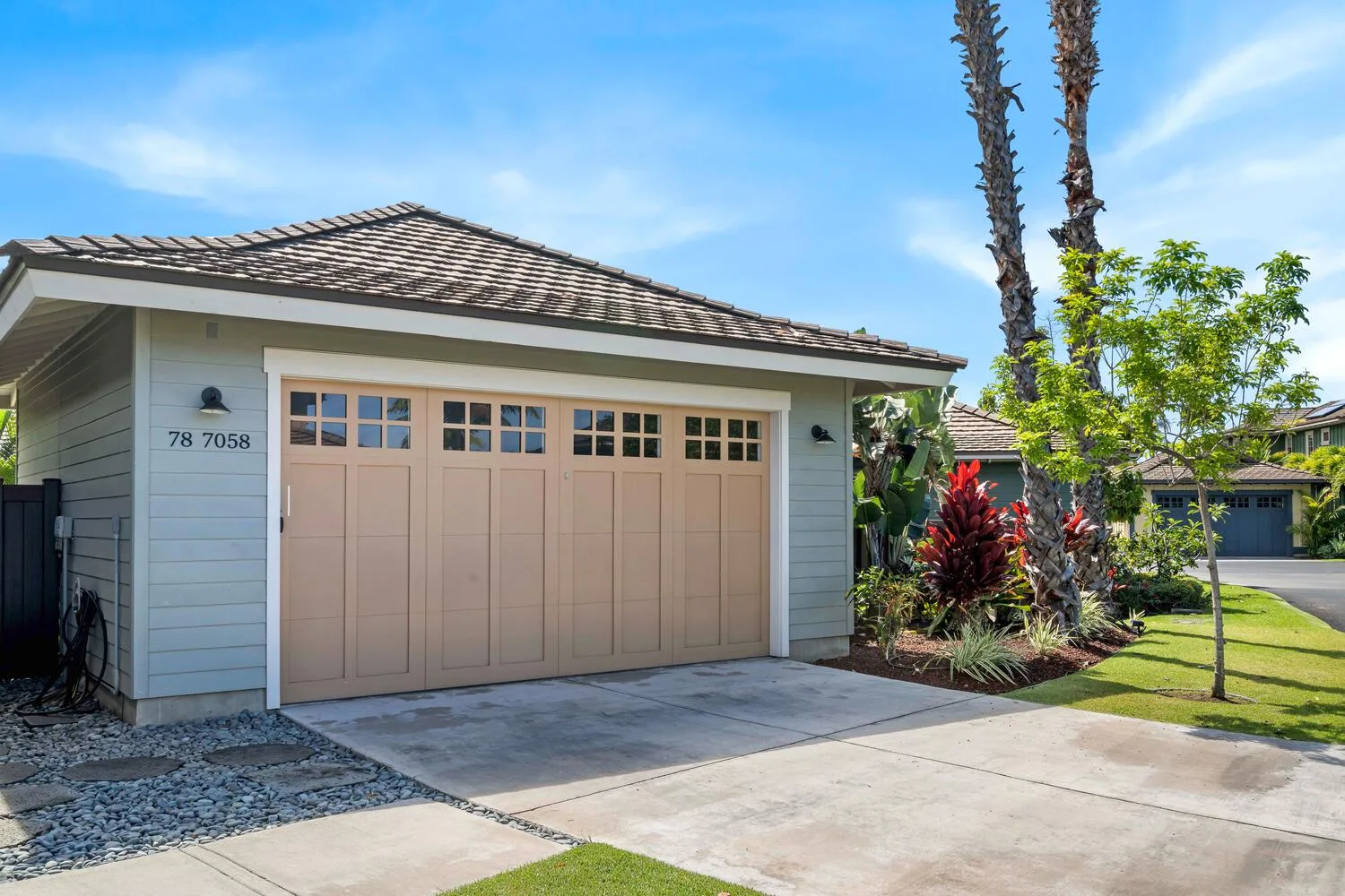 A residential garage with a wide door faces a paved driveway.