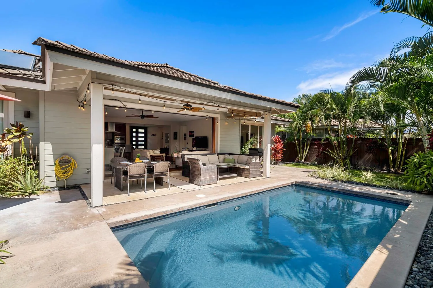 A swimming pool beside a covered outdoor seating area.