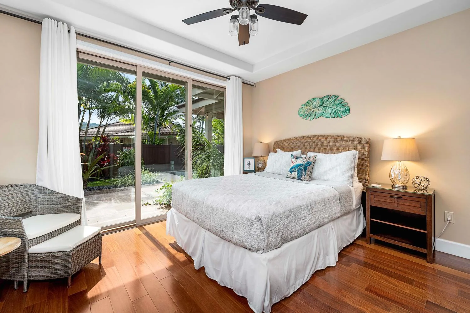 A bedroom with a bed beside sliding glass doors overlooking greenery.