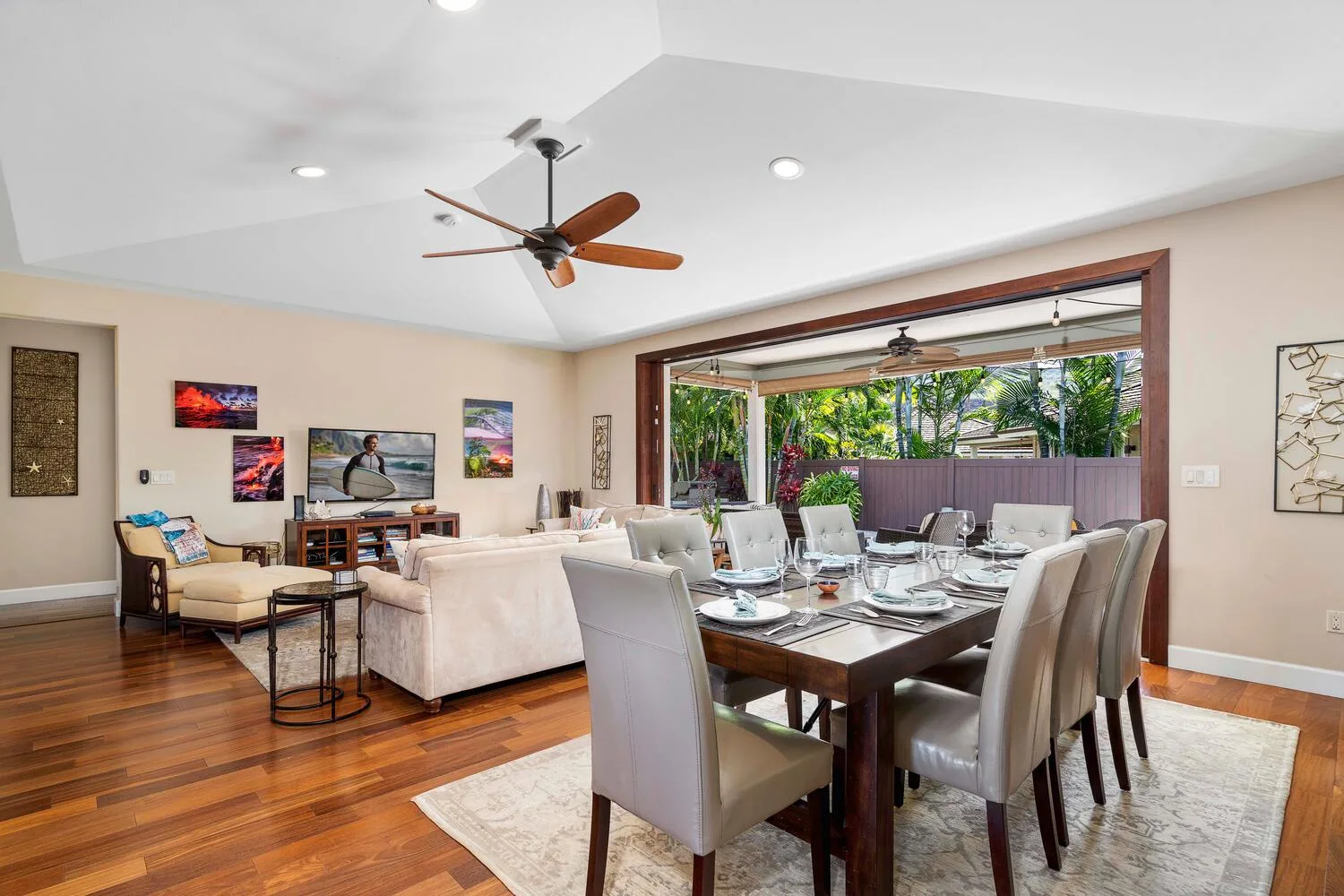 A living and dining room opens onto a patio, with a set dining table.