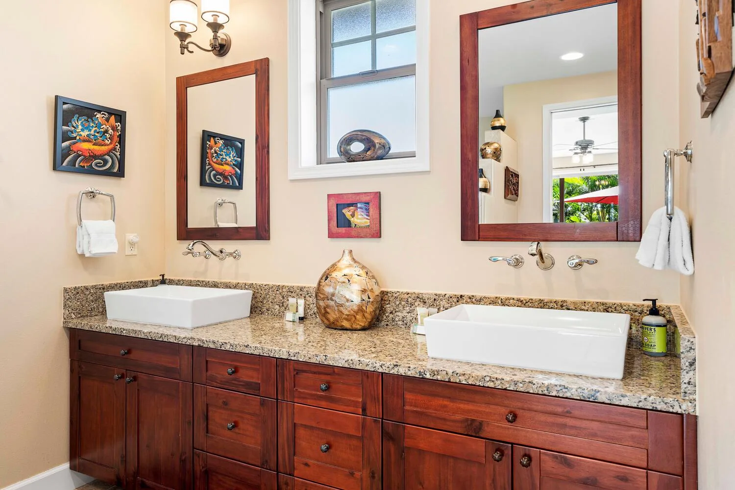 A bathroom vanity with two sinks, wooden cabinetry, and mirrors.
