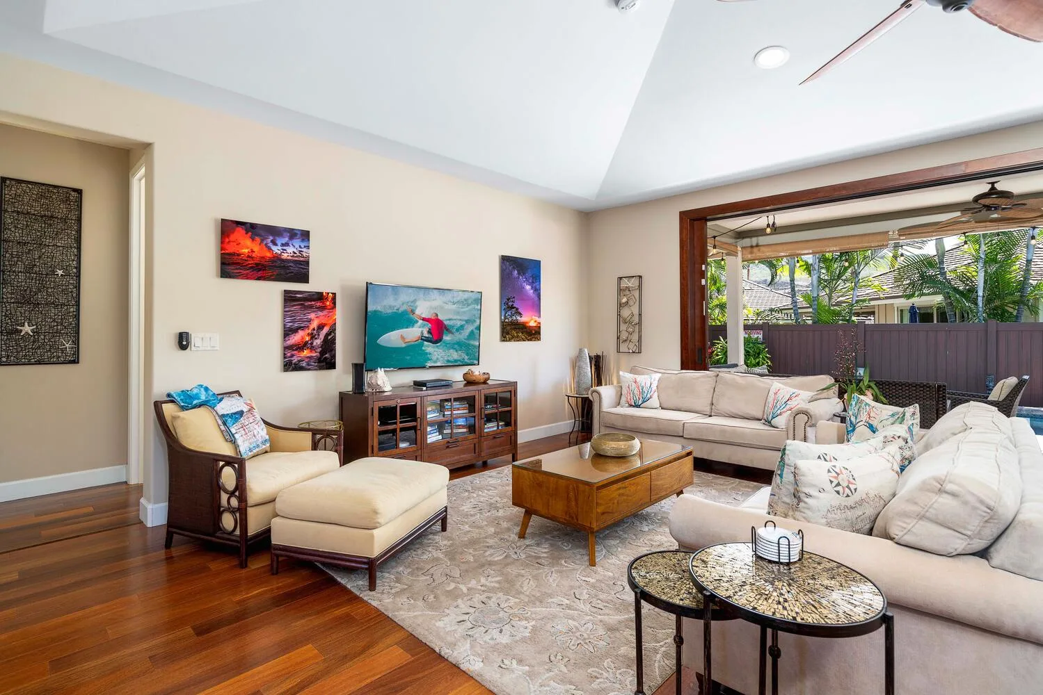 A living room with comfortable seating, a coffee table, and a large open window.