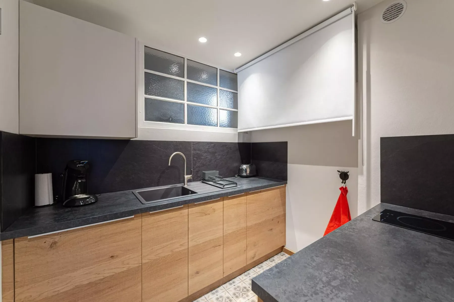 Una cocina moderna con gabinetes de madera y una encimera oscura.