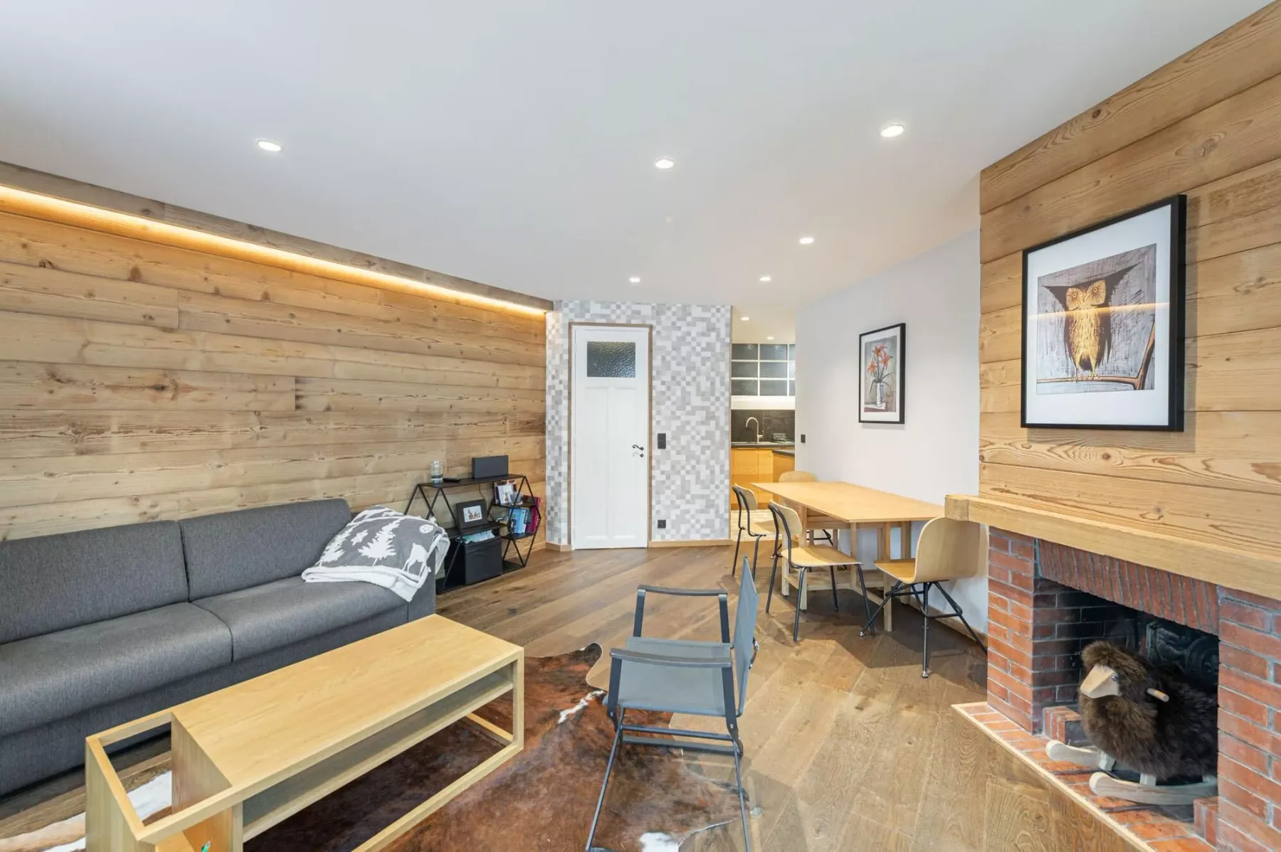 Una sala de estar con asientos, una mesa de comedor y una chimenea de ladrillo.