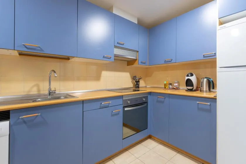 A kitchen with blue cabinets, a countertop, and a sink.