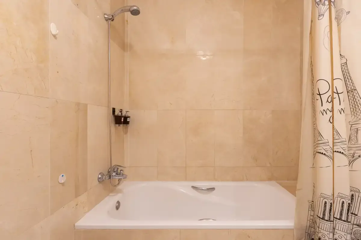 A tiled bathroom with a bathtub and shower.