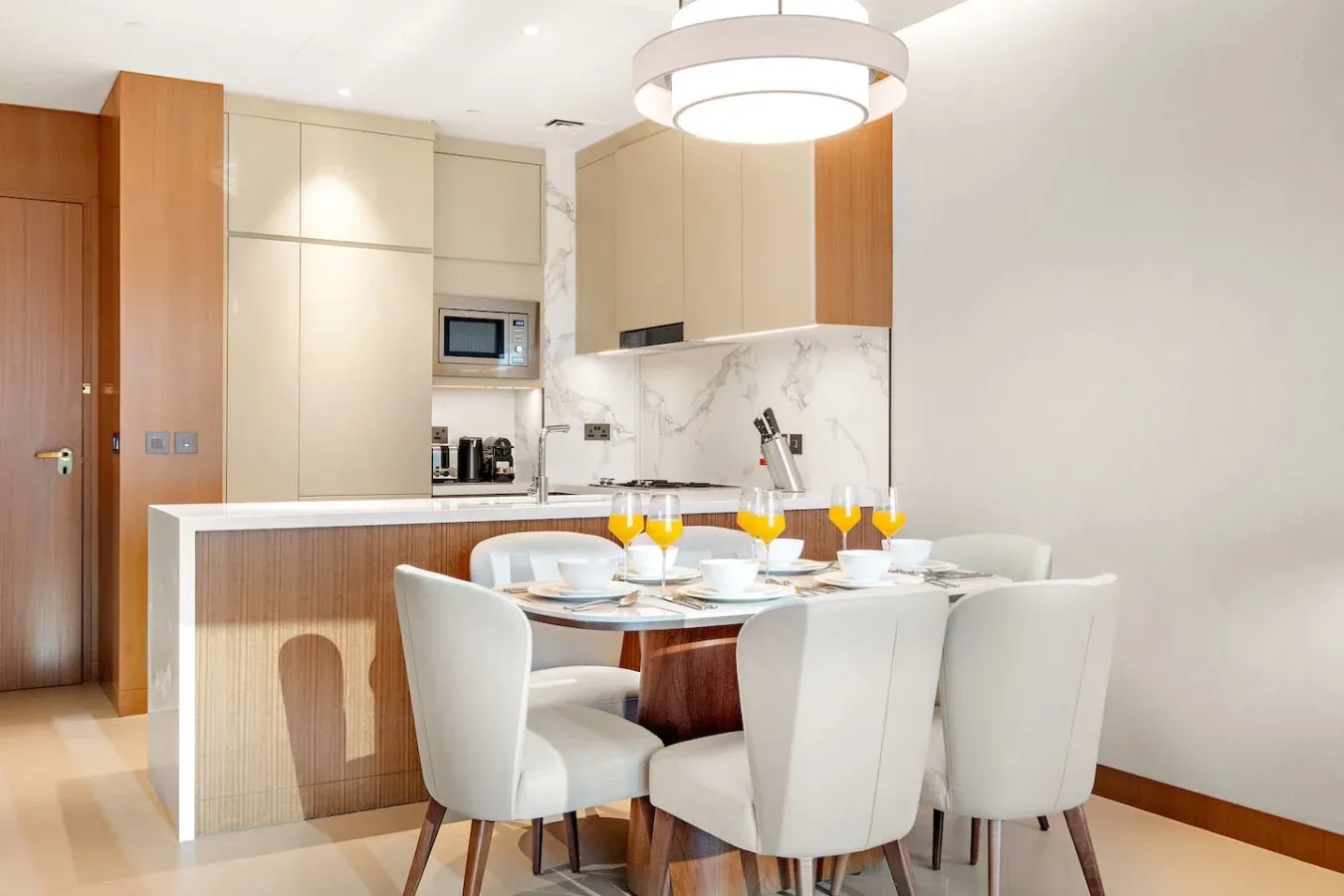 A bright dining area with a set table beside a modern kitchen.