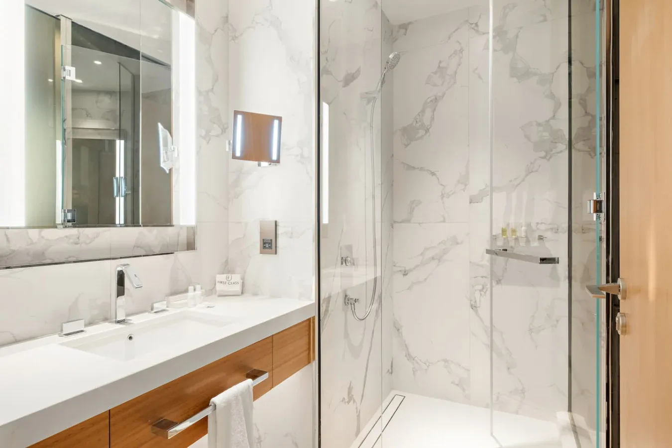A bright bathroom with a long vanity and a glass shower.