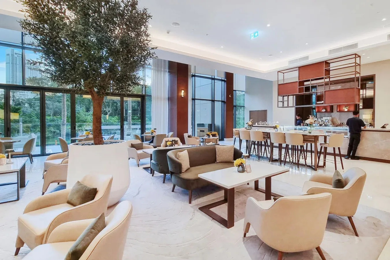 A bright lounge with seating around low tables and a long bar.