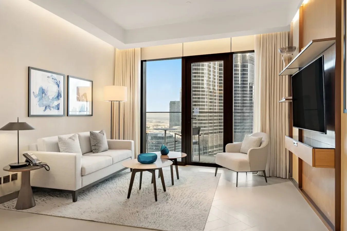A modern living room with seating, a coffee table, and floor-to-ceiling windows.