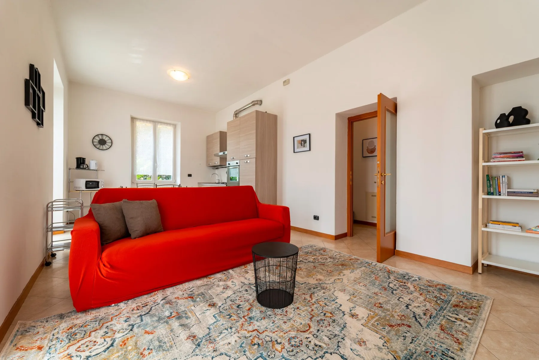 Living room with bright red seating, a patterned rug, and a small round table.