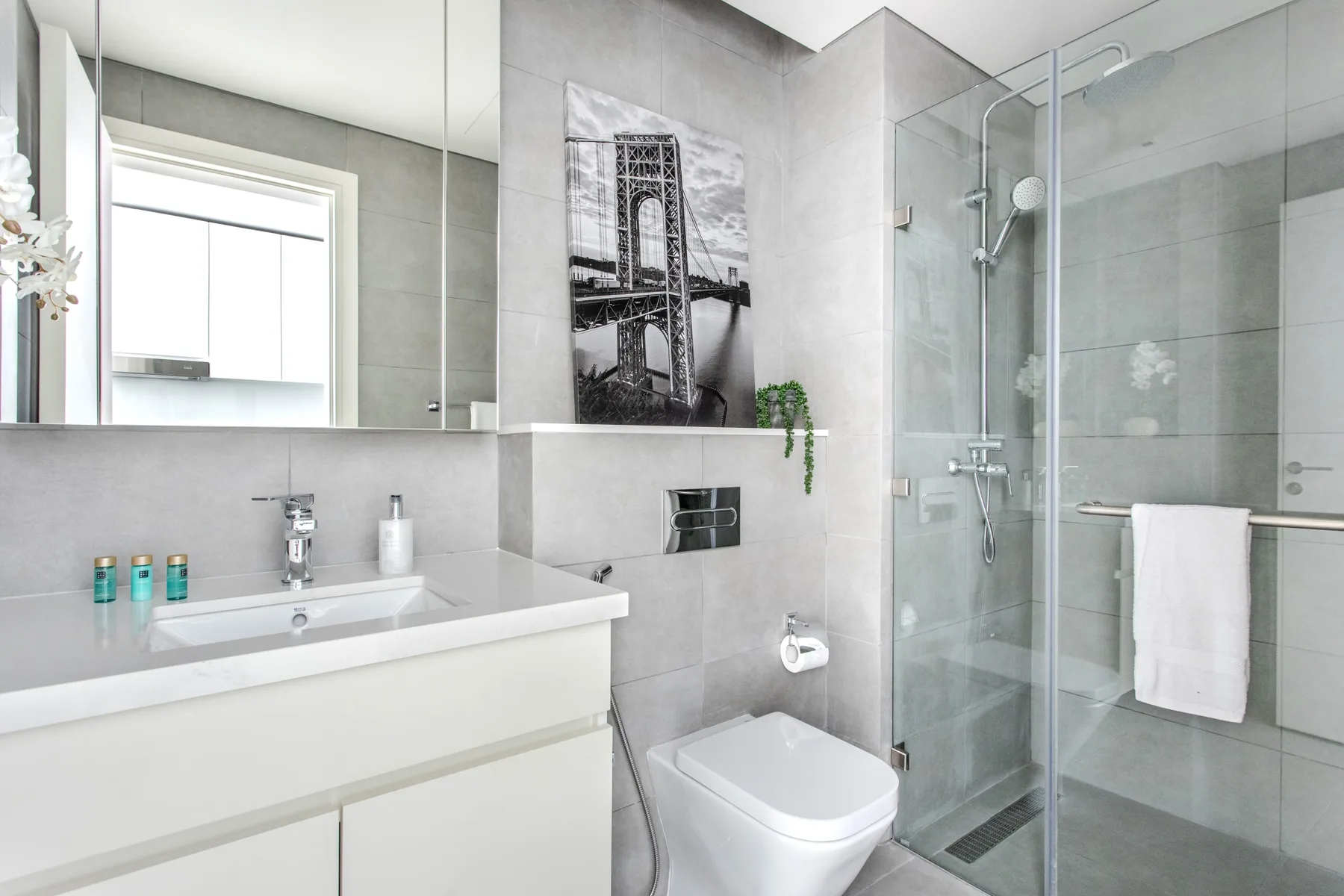 Un baño moderno con lavabo, inodoro y ducha de vidrio.