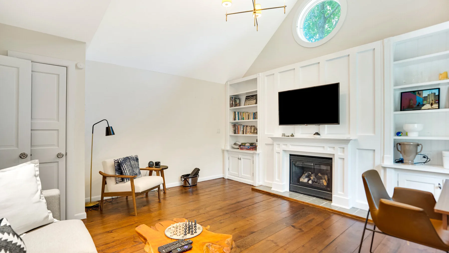 Una sala de estar luminosa con chimenea, televisor y asientos.