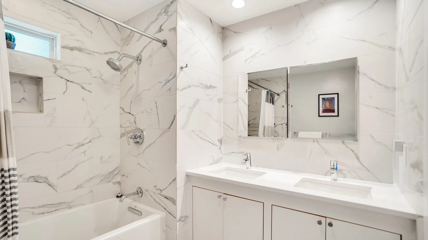 Un baño luminoso con bañera, ducha y un amplio lavabo.