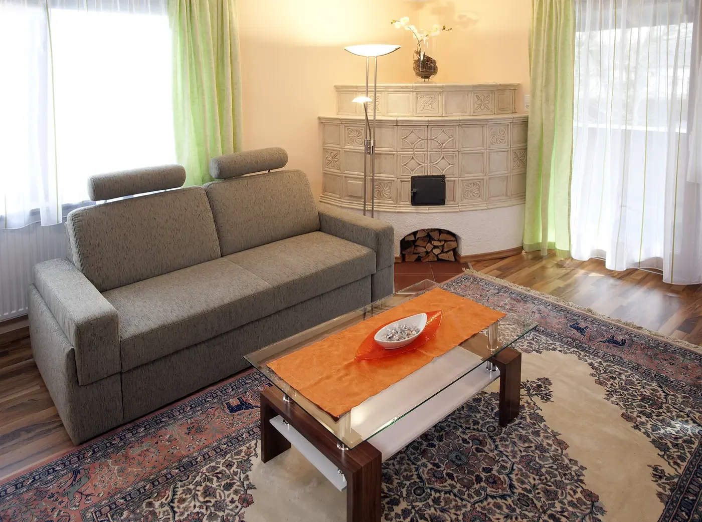 Living area of Suite 112 with sofa and tiled stove