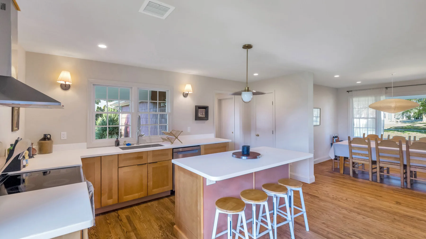 An open kitchen and dining area with a central island and wooden flooring.