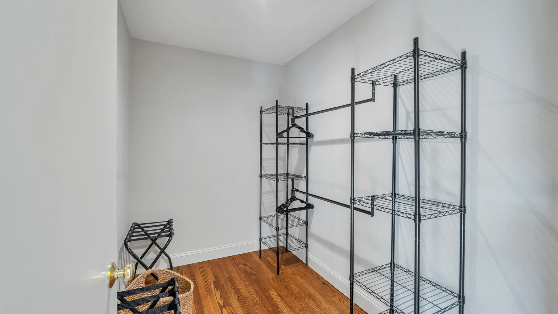 A small room with metal shelving and a wooden floor.