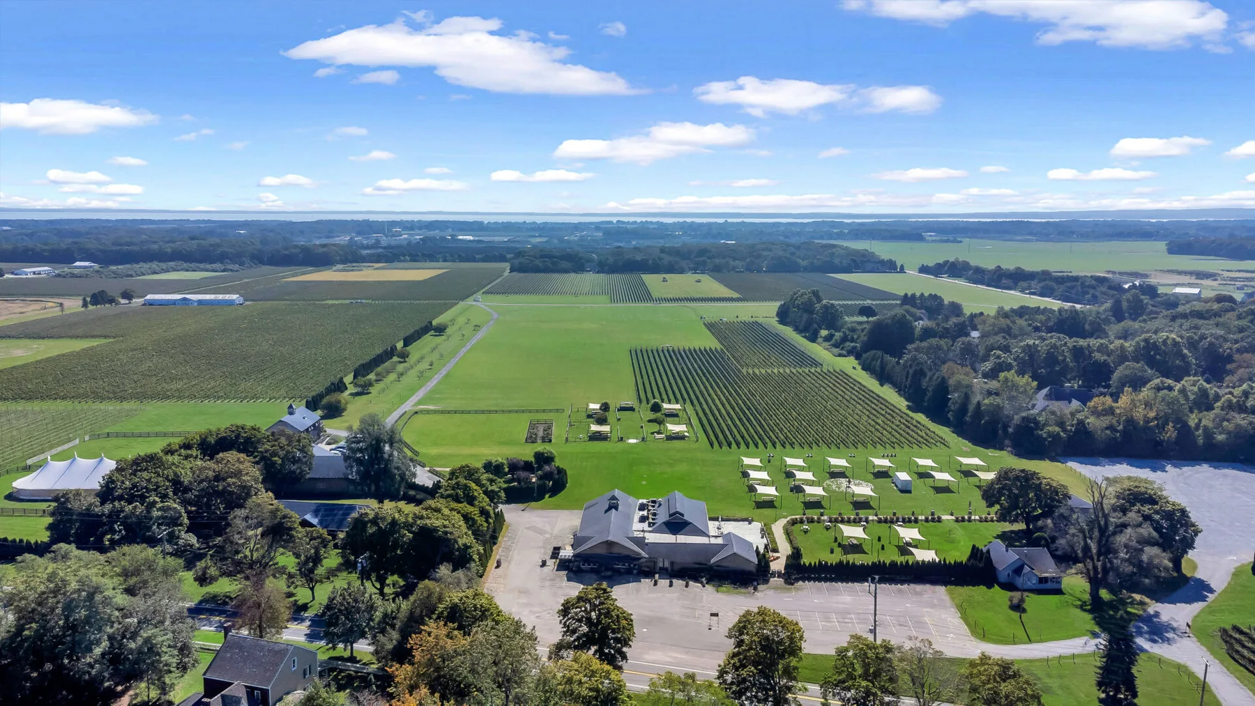 An aerial view of a rural property surrounded by fields, trees, and open farmland.