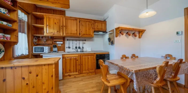 A kitchen and dining area with wooden cabinets and a dining table.