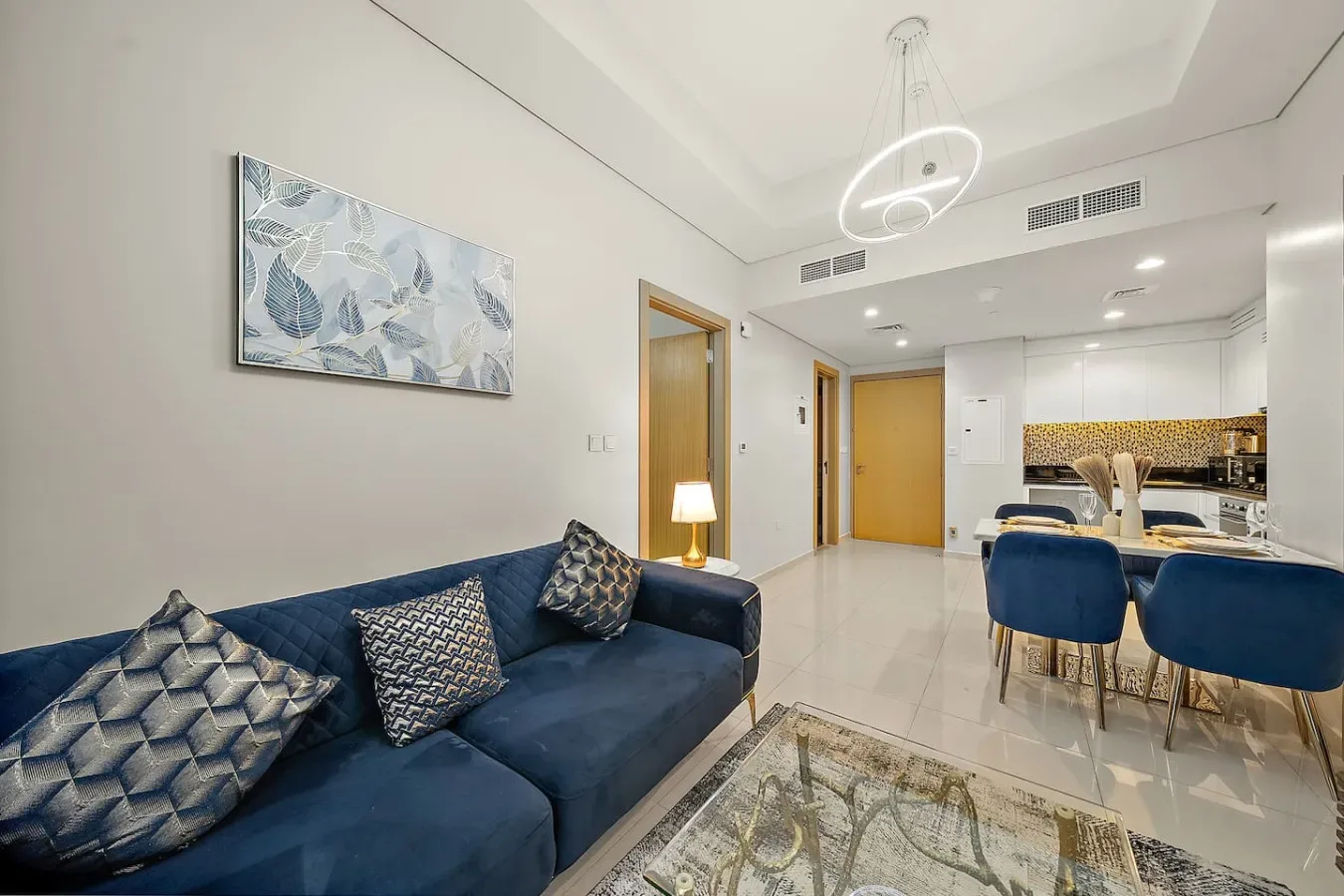 Una sala de estar y comedor moderna con asientos azules y una mesa de comedor.