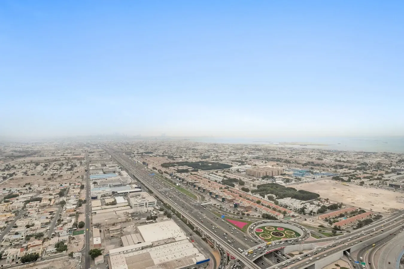Vista aérea de una ciudad extensa con carreteras y edificios bajo un cielo despejado.