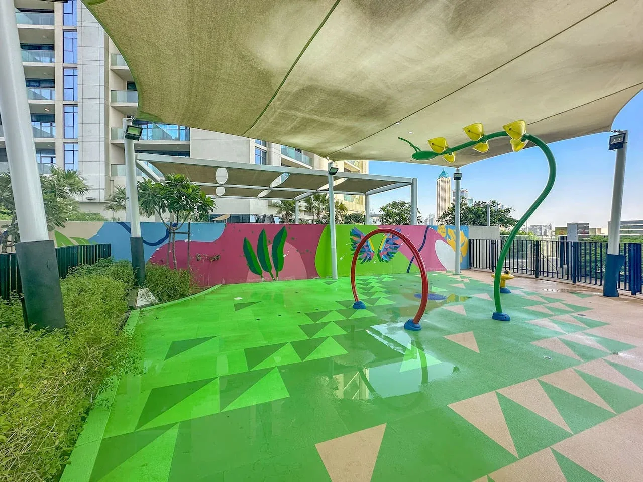 Una zona exterior de juegos acuáticos con suelo colorido y estampado.