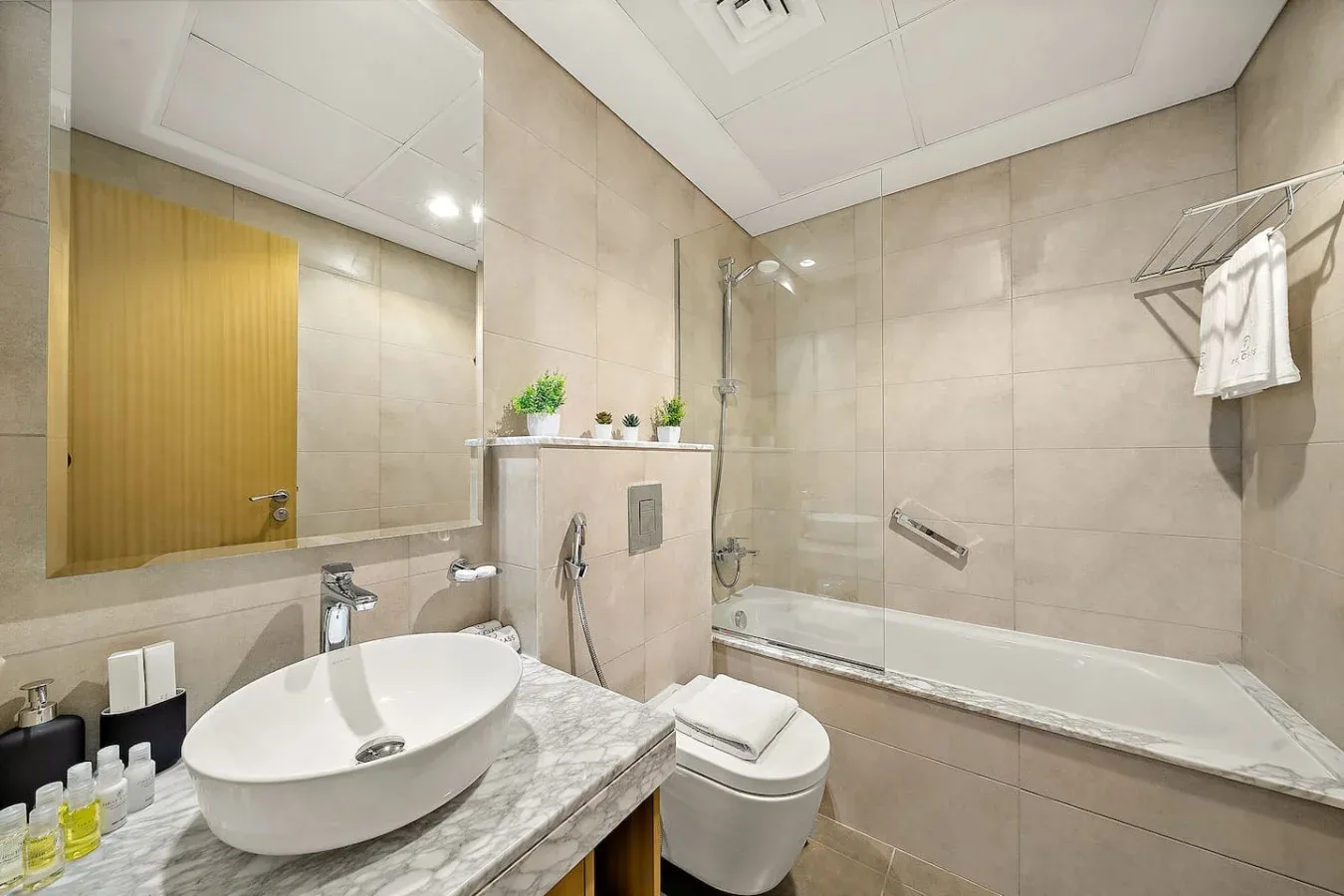 Un baño con azulejos, lavabo, inodoro y bañera.