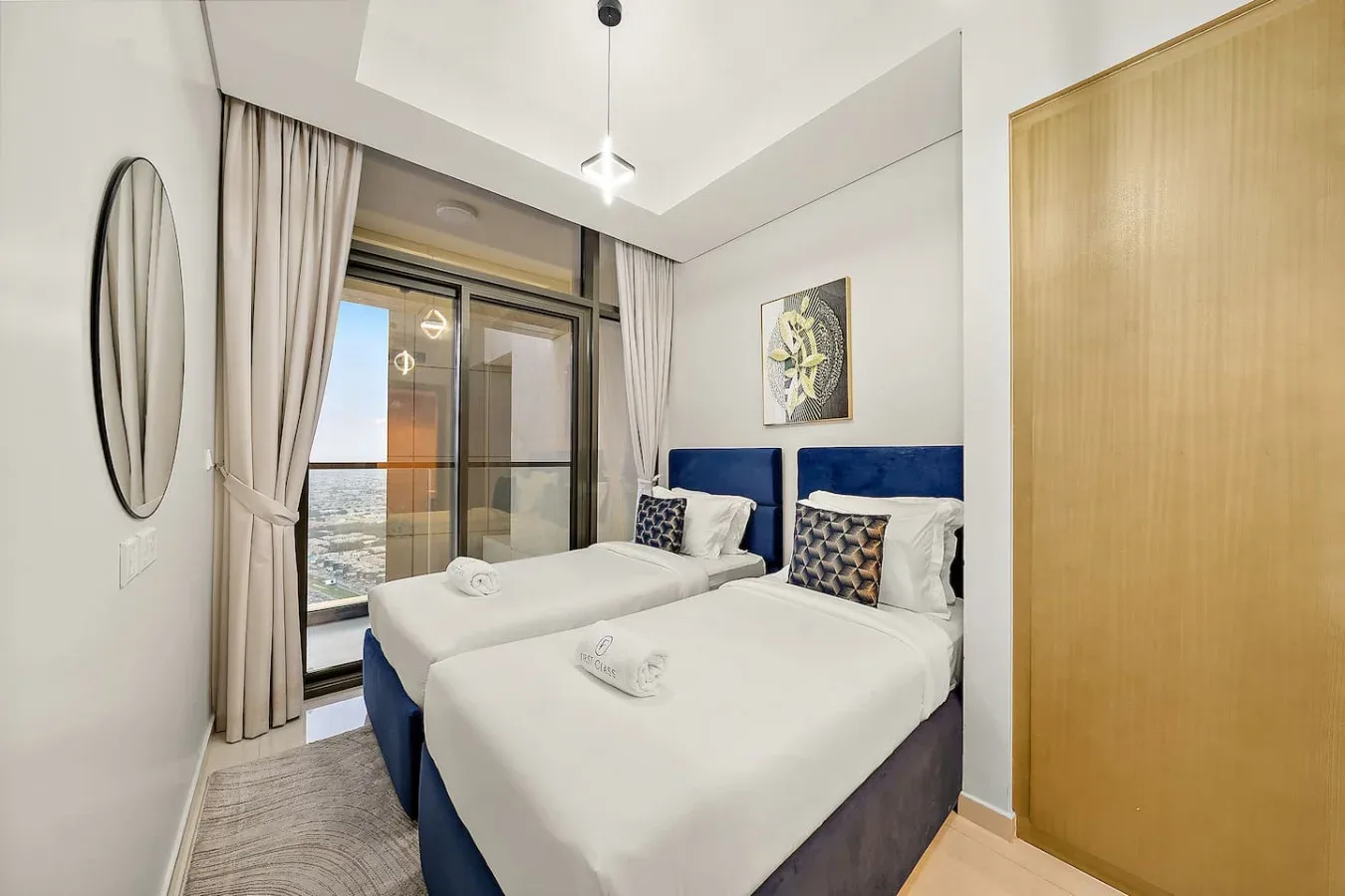 Un dormitorio con dos camas junto a una ventana grande con vistas al agua.