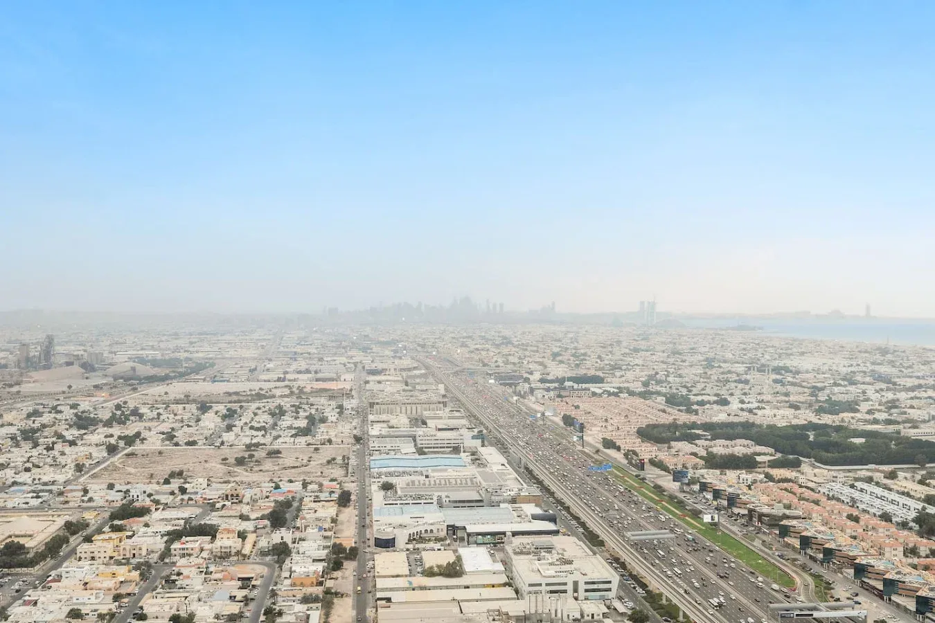 Vista aérea de una extensa ciudad con una autopista que se extiende hacia el horizonte.