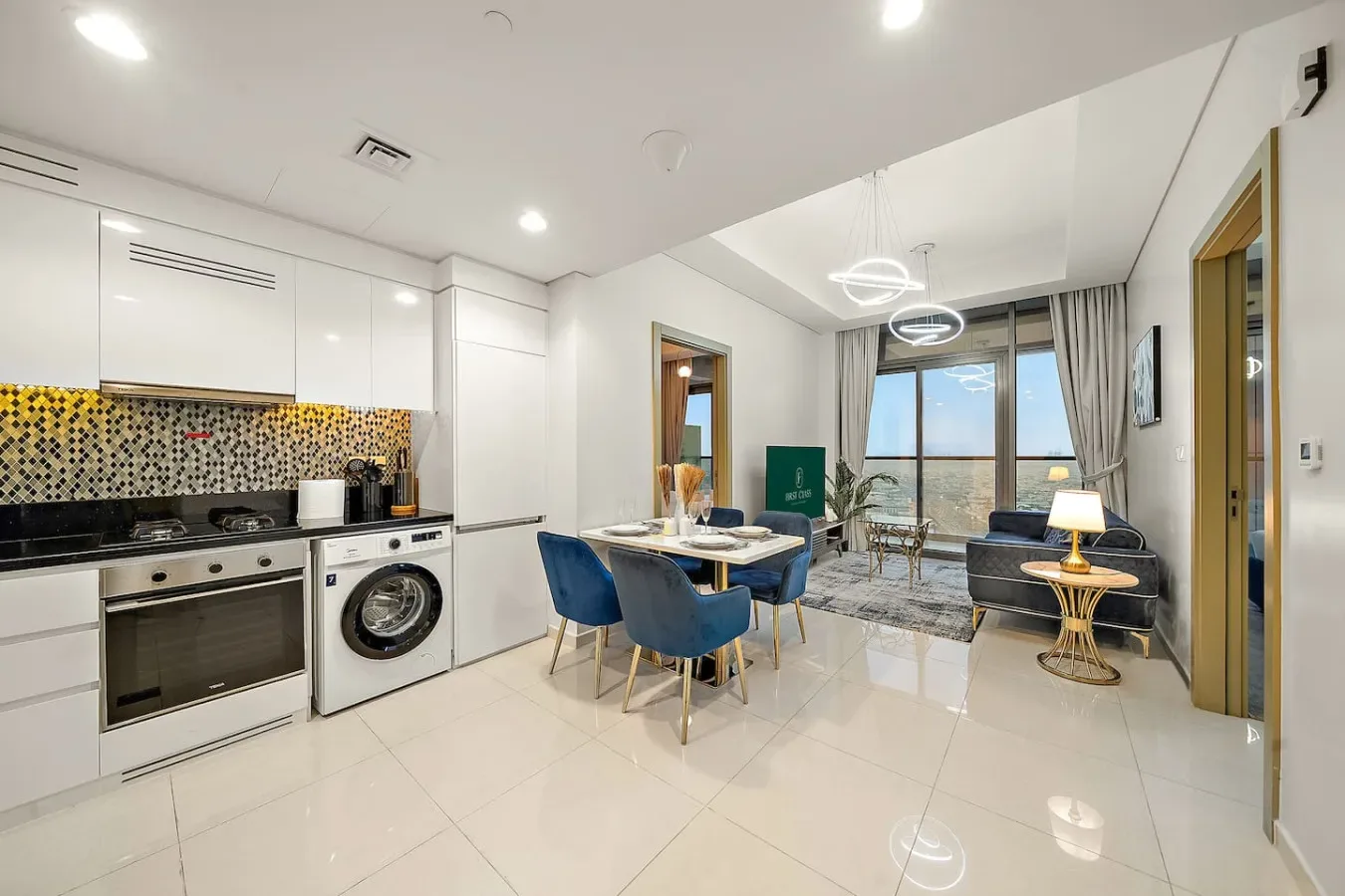Una cocina-comedor luminosa y abierta da a un balcón con grandes ventanales.