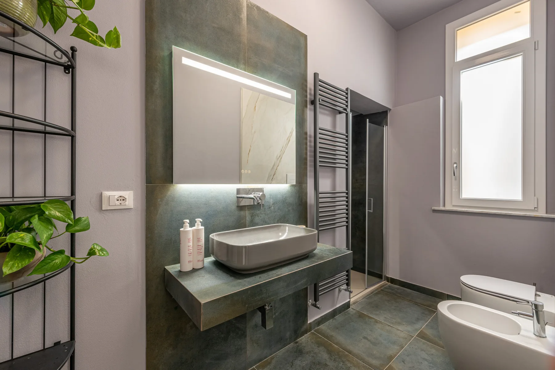 Un baño moderno con un lavabo suspendido y una ventana luminosa.