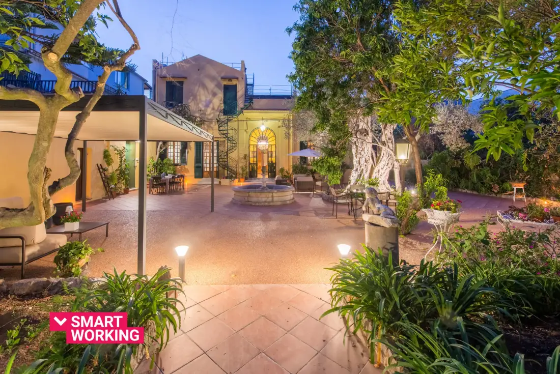A landscaped courtyard with a central fountain, seating, and surrounding trees.