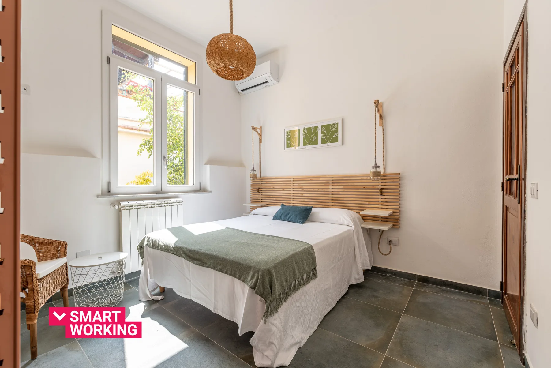 A bright bedroom with a bed beneath a wooden wall-mounted headboard.