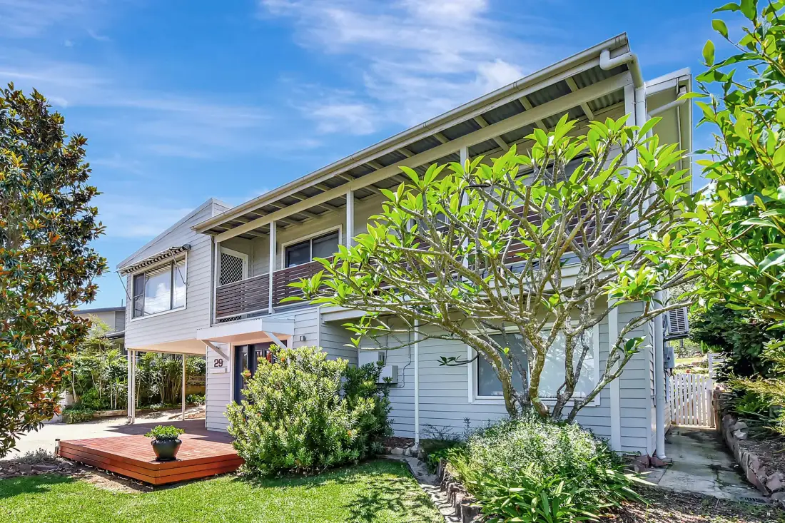 A two-story house with a small deck and garden.