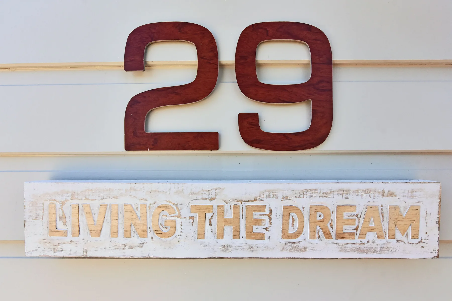 A wall displays the number 29 above a sign reading “Living the Dream.”