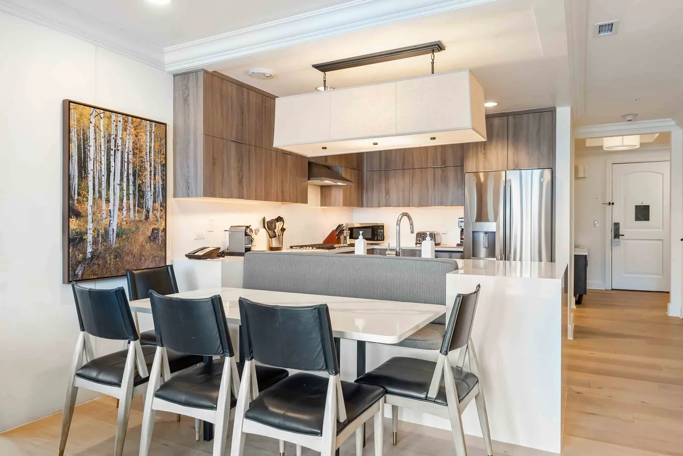 Cocina y comedor modernos con una barra, una mesa y sillas.