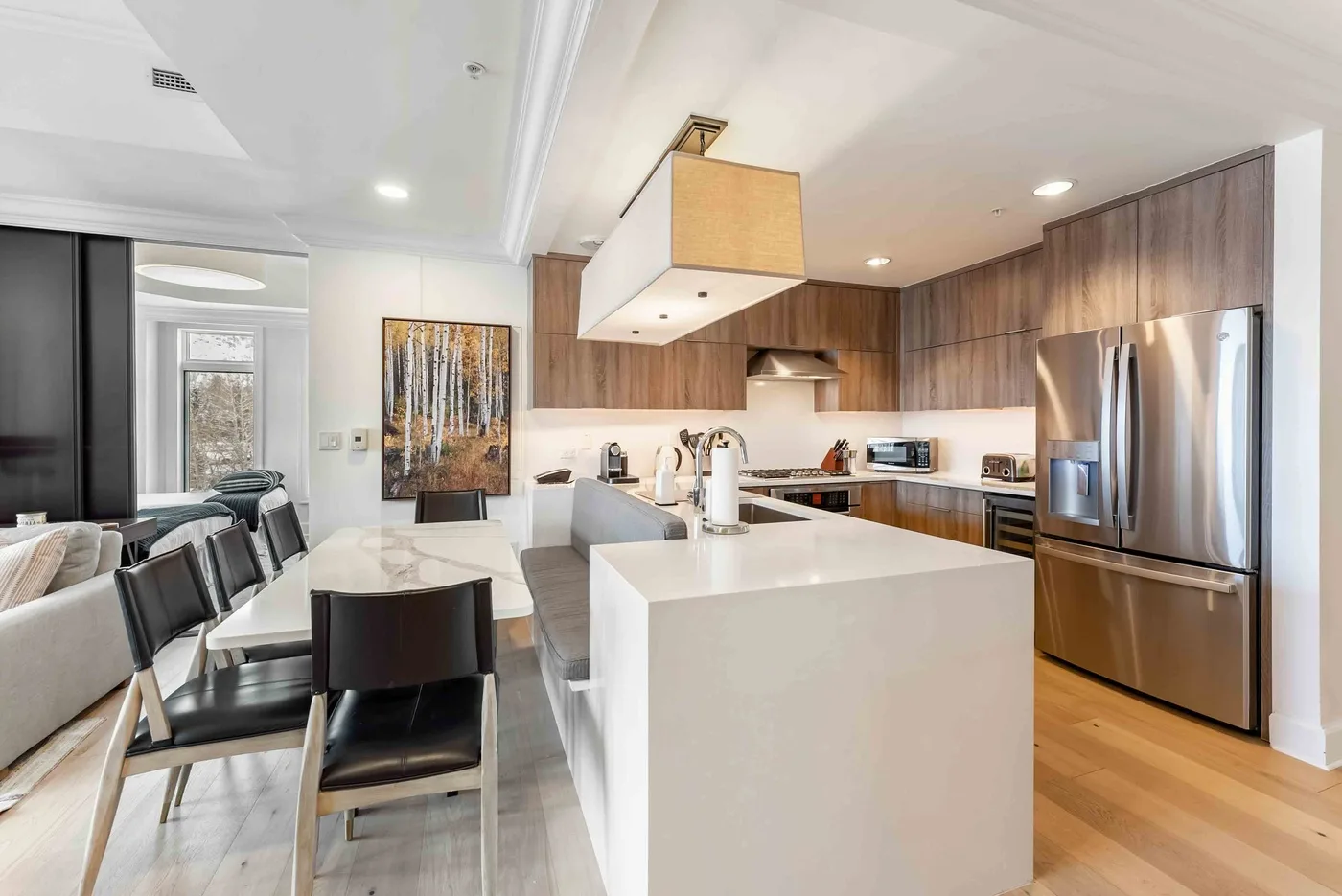 Una cocina y comedor de concepto abierto con una isla central y una mesa de comedor.