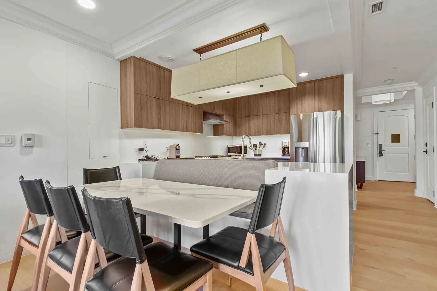 Un comedor con mesa y sillas junto a una cocina moderna.