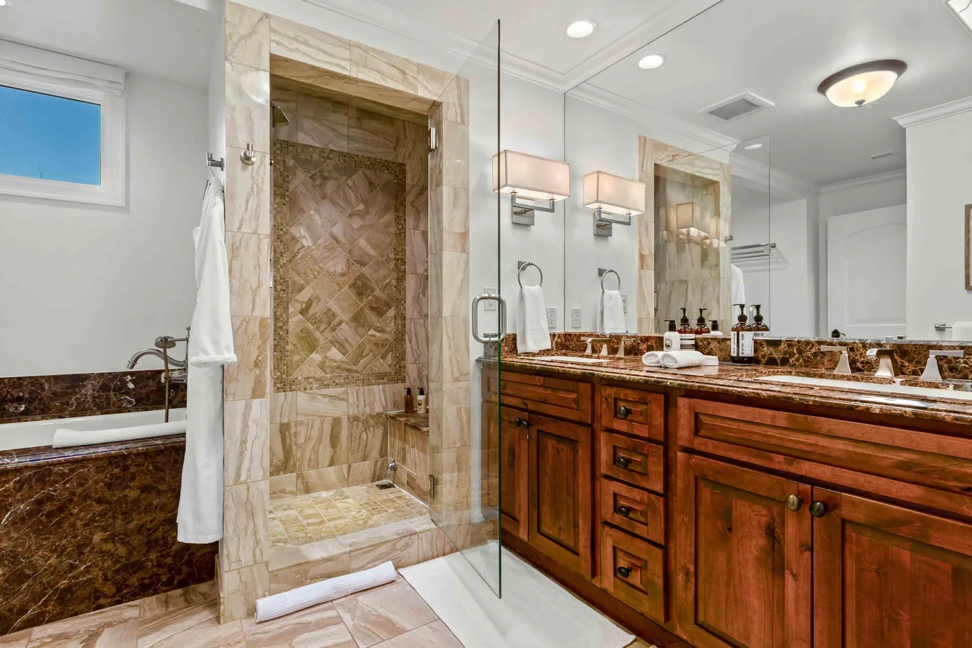 Un baño con ducha de cristal, bañera y un largo tocador de madera.